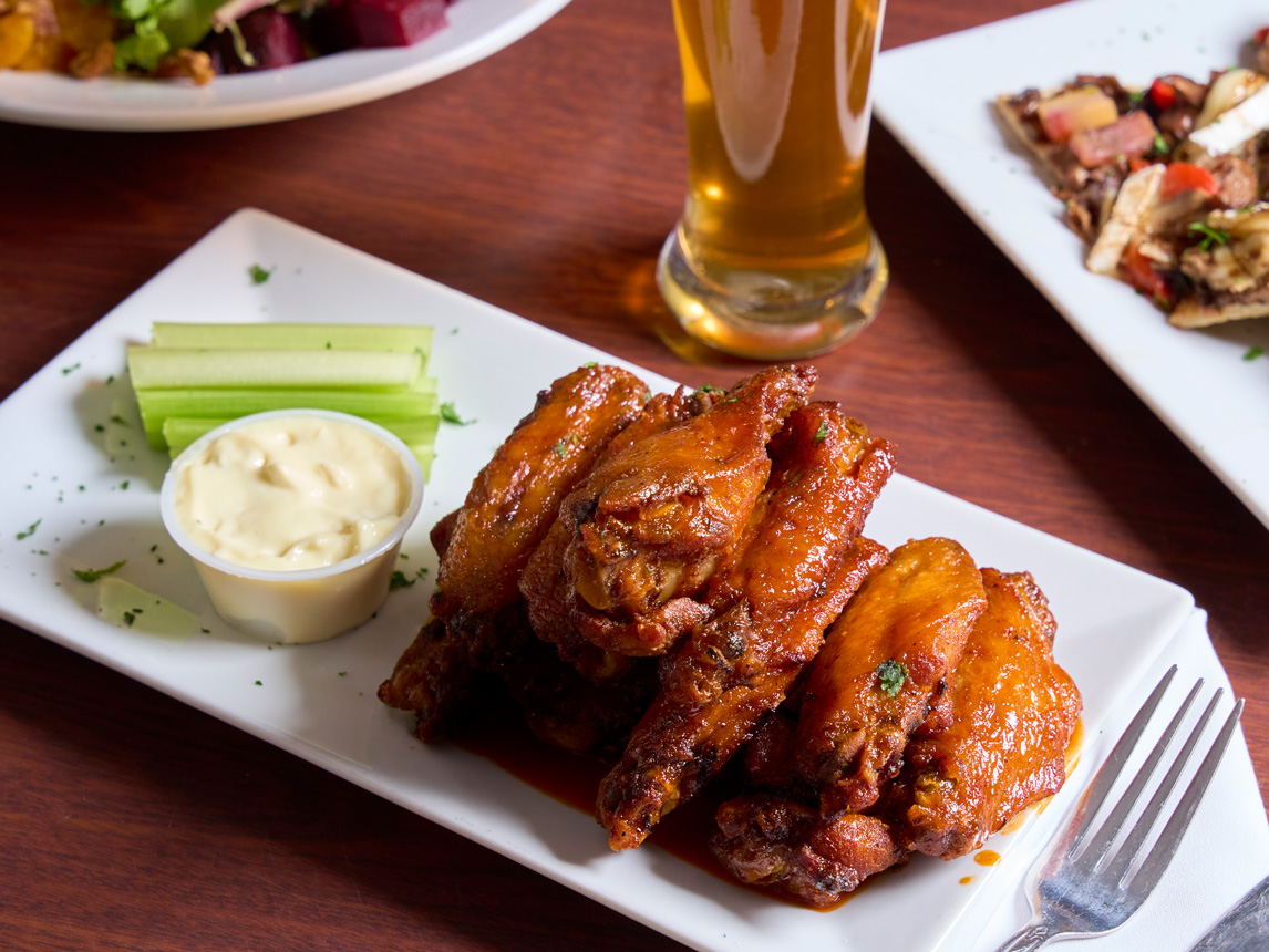 Robin’s Nest Wings - Lightly Fried, naked, house made tangy garlic buffalo sauce, served with bleu cheese and celery - Prepared by Robin’s Nest Mount Holly