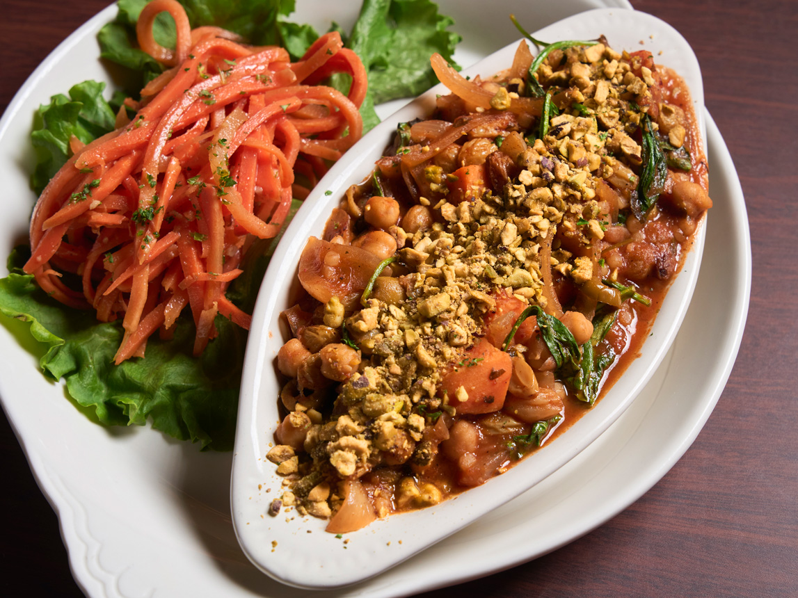 Moroccan Tagine - Sweet Potato, chickpeas, in a tagine sauce, golden raisins, green olives, tomato, onions, spinach, over pearl couscous, topped with roasted pistachios, served with a chilled carrot salad - Prepared by Robin’s Nest Mount Holly